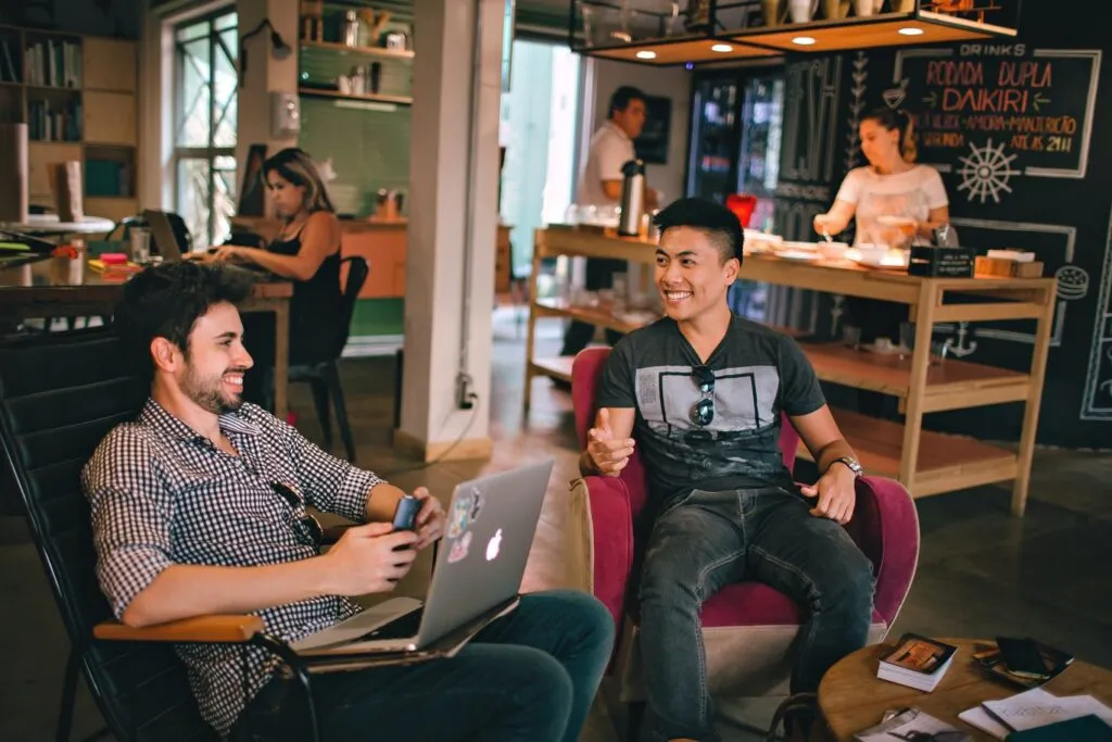 group of youg people gathered in a living room enjoying of a conversation