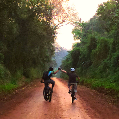 couple riding bikes, and clapping hands in the Jaguarete Trail, in Iguazu Falls.