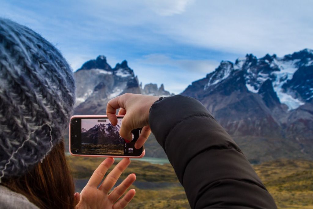 Woman taking a photo on Torres del Paine hike.