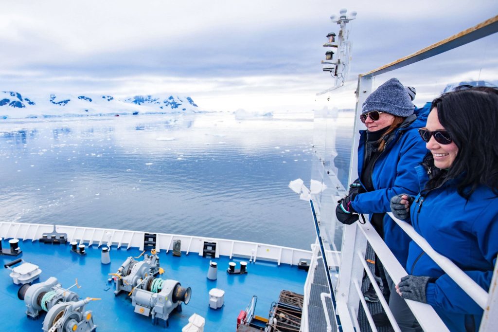 two persons looking at antactica landscape