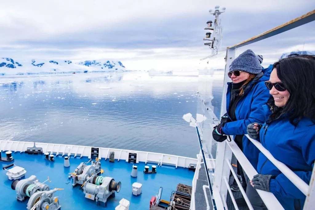 two persons looking at antactica landscape