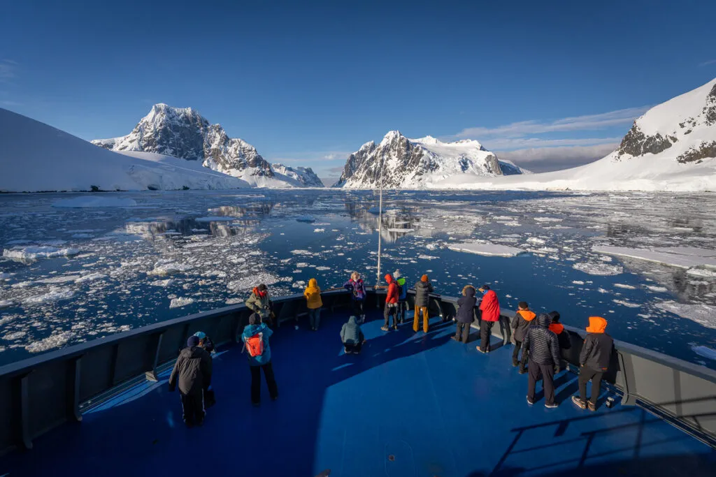 Front of antarctica cruise with people looking the landscape