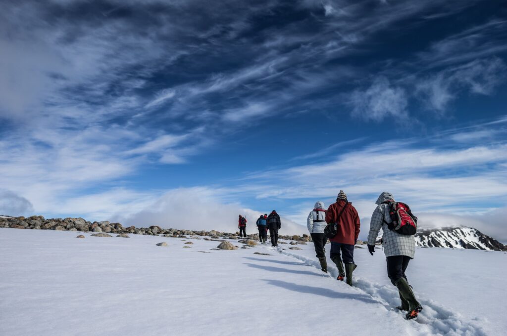 A group of peolple hiking on snowy underground in the Antarctica continent