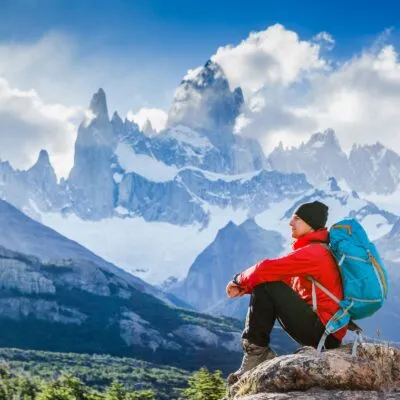 Hiker taking a rest in a trail of El Chalten, admiting the Fitz Roy Mount.
