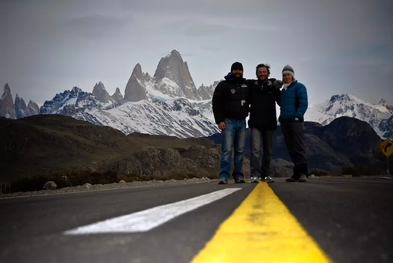 tree guys on the road with cerro fitz roy on the back