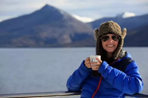 Woman with a cup a mountain view in Ushuaia.